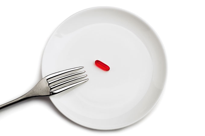 foto de prato branco com pílula vermelha em cima