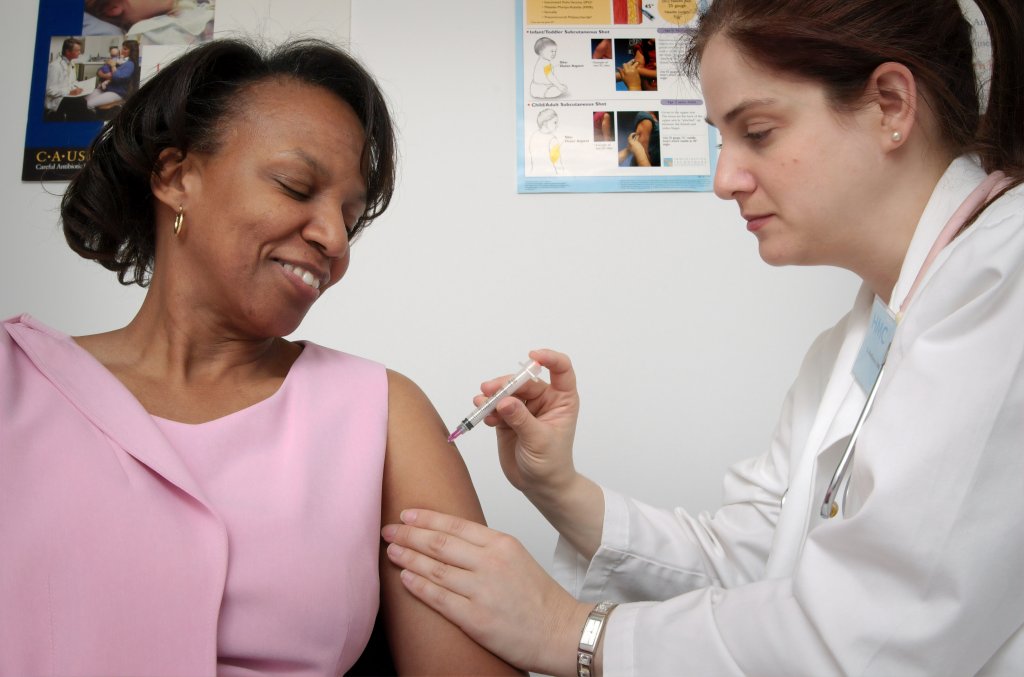 Foto de mulher recebendo a vacina da gripe, em referência à campanha nacional de vacinação contra a gripe de 2021