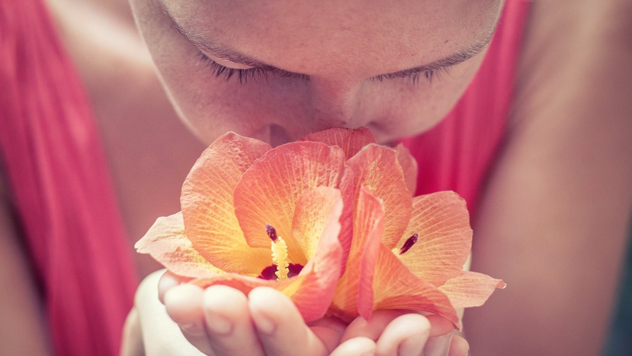 Mulher cheirando flor