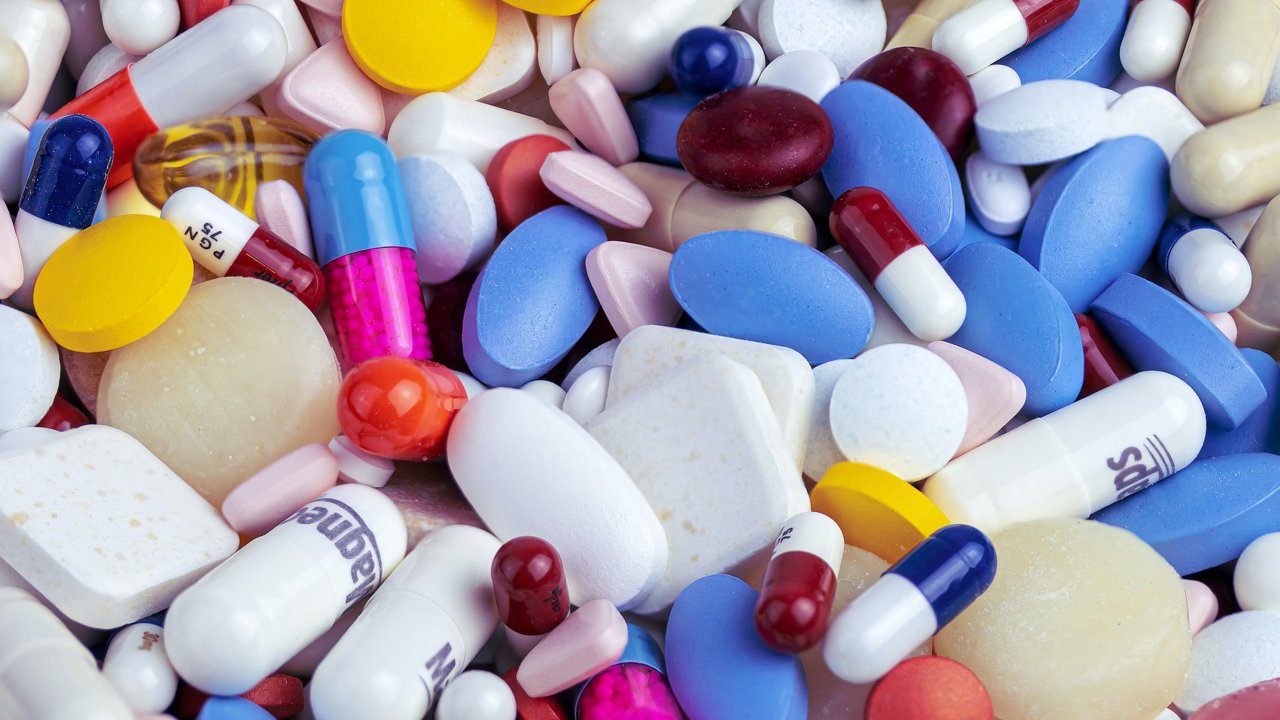 Vários comprimidos de diferentes cores empilhados