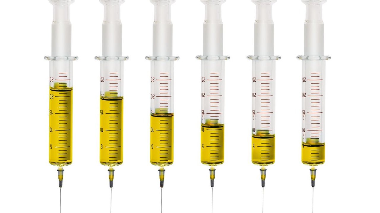 Foto de várias seringas diferentes, com líquido amarelo dentro delas