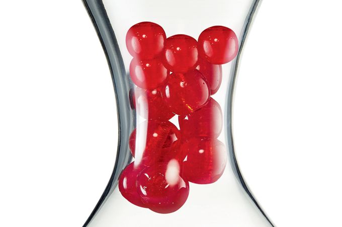 tubo de vidro com esferas vermelhas representando um coágulo sanguíneo
