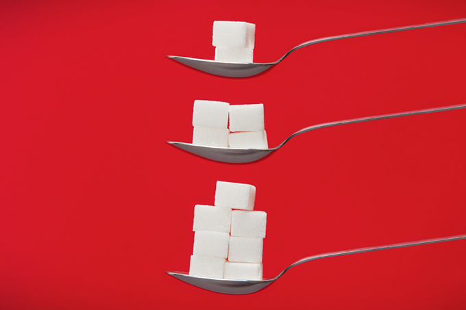 foto de cubos de açúcar em colheres demonstrando quantidade diária de consumo de açúcar