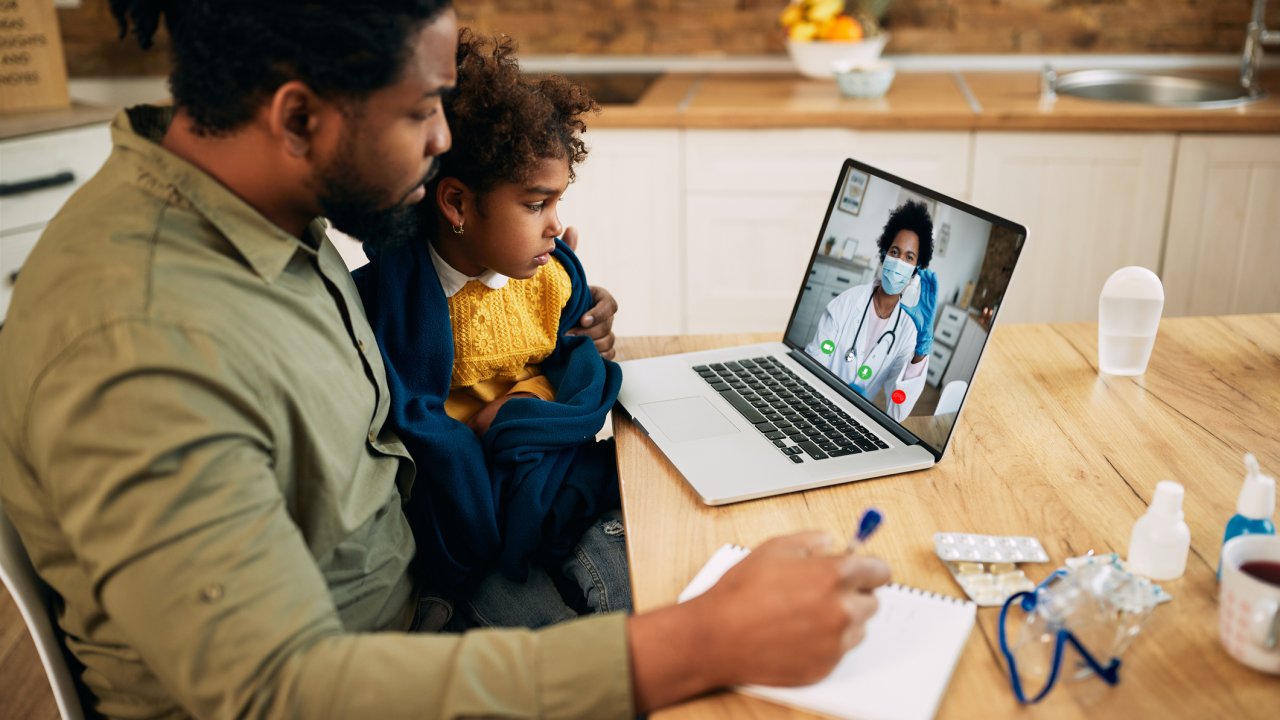 Pai e filha realizam teleconsulta com profissional da saúde