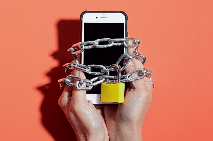 foto de mãos presas a celular com correntes e cadeado