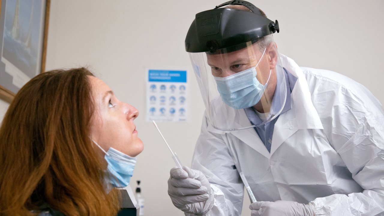 Mulher fazendo teste de antígeno com swab nasal para Covid-19
