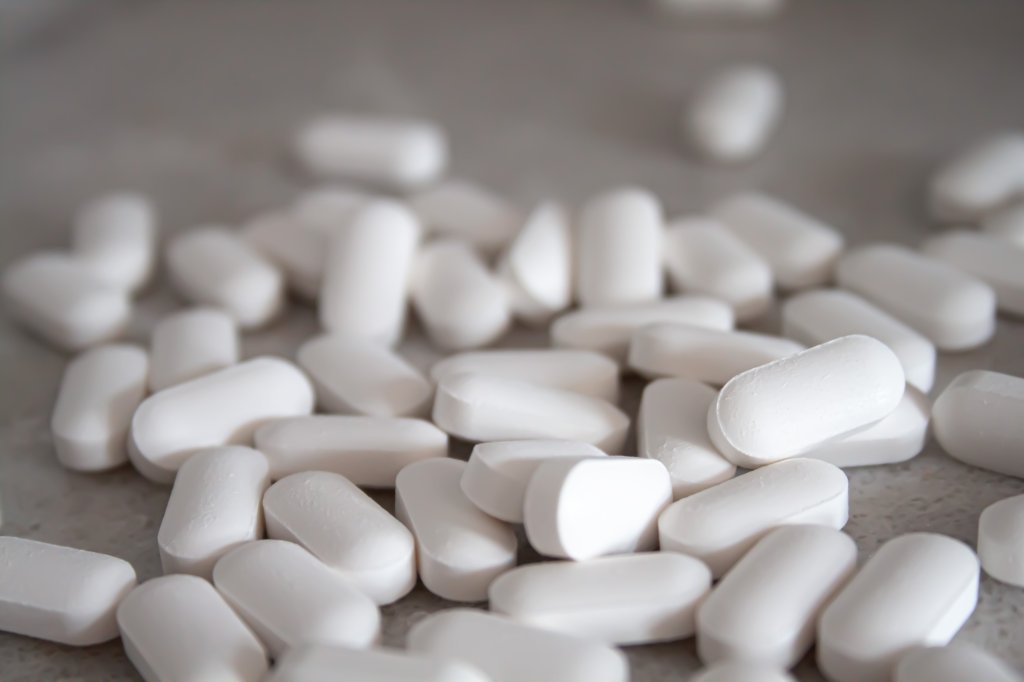 Remédios brancos que simbolizam a azitromicina e seus efeitos
