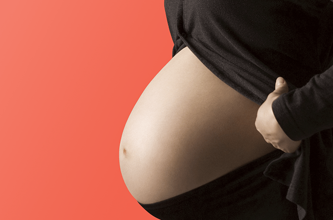 Foto de mulher grávida com roupa preta em fundo vermelho