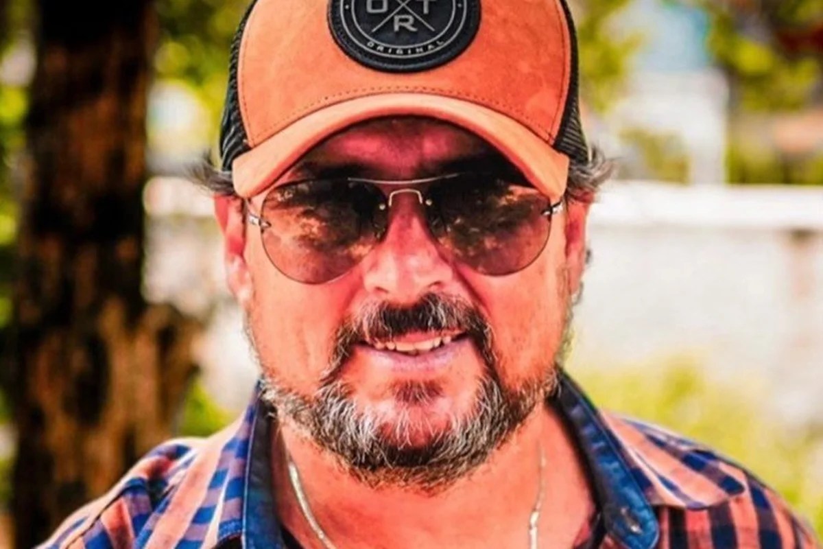 Homem de boné, óculos escuros, barba e bigode